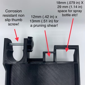 May include: Black plastic 3D printed tool holder with two slots. The larger slot is 1.14 inches by .79 inches and the smaller slot is .51 inches by .42 inches. The holder has a thumb screw for tightening.