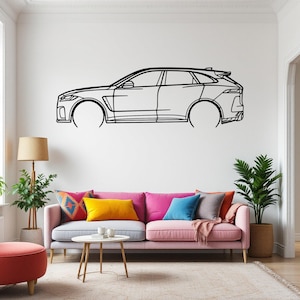 May include: A black and white line drawing of a car on a white wall. The car is a SUV with a rounded roof and a large front grille. The car is in a living room setting with a couch, a coffee table, and plants.