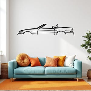 Può includere: Un'opera d'arte da parete in metallo nero che presenta il contorno minimalista di un'auto decappottabile. Il design cattura il profilo laterale del veicolo, inclusi il parabrezza, i sedili e la carrozzeria, in uno stile a linea continua.