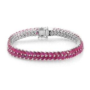 May include: A silver tennis bracelet with a double row of marquise-shaped ruby stones.