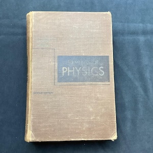 May include: A vintage book titled "Elements of Physics" in a light brown cover. The title is in a blue rectangle. The book is a second edition.
