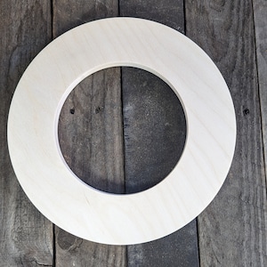 May include: A set of three ceramic mugs with a speckled, cream-colored glaze. Each mug features a different hand-painted design: a blue and green leaf, a yellow flower, and a red berry. The mugs have a simple, rounded shape and a comfortable handle.