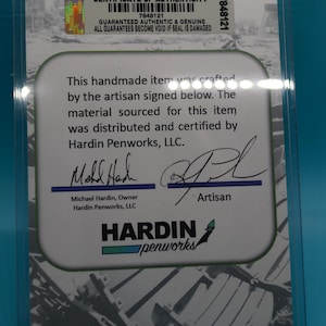 May include: Certificate of Authenticity for a handmade item. The certificate is white with black text and a black and white image of a chair. The text states that the item was crafted by the artisan signed below. The material sourced for this item was distributed and certified by Hardin Penworks, LLC. The certificate is signed by Michael Hardin, Owner of Hardin Penworks, LLC and the artisan.