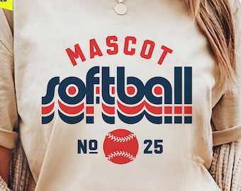 May include: A beige t-shirt with a retro-style graphic design that says "MASCOT softball" with a baseball and the numbers "NO. 25". The font is included for the text "MASCOT" and the player number.