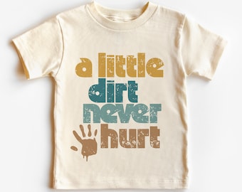 May include: A beige t-shirt with a vintage-style graphic that says "a little dirt never hurt" with a brown handprint underneath. The text is in a variety of colors, including yellow, blue, and green.