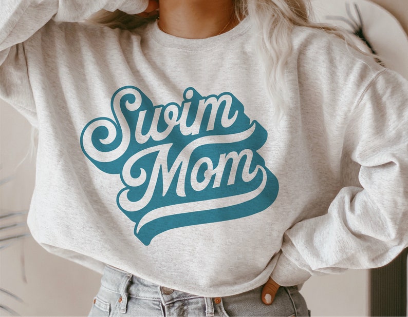 May include: A gray sweatshirt with the text "Swim Mom" in a blue retro font.