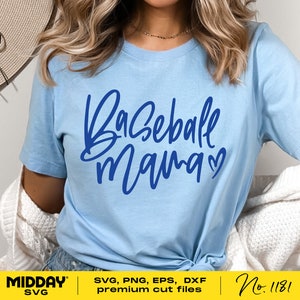 Peut inclure: Un t-shirt bleu clair avec le texte "Baseball Mama" en &eacute;criture bleue avec un symbole de c&oelig;ur. Le texte est centr&eacute; sur le t-shirt.