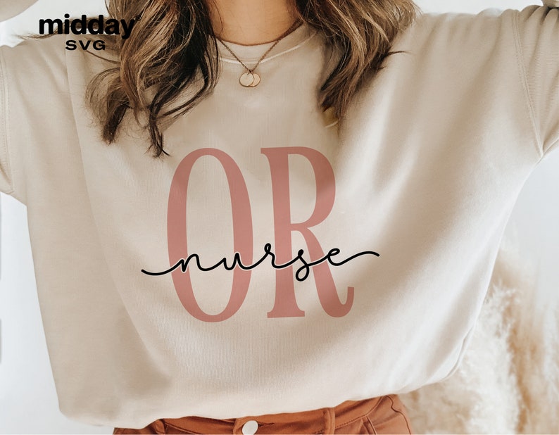 May include: A white sweatshirt with the letters "OR" in pink and the word "nurse" written in cursive underneath.