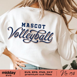 以下が含まれることがあります： 白いスウェットシャツに「MASCOT Volleyball」という文字が青と茶色の文字で書かれています。文字は影付きのスタイリッシュなフォントで書かれています。スウェットシャツは人が着用しています。