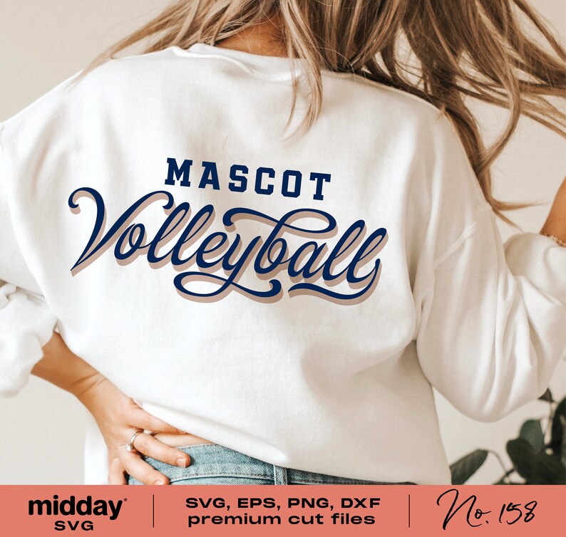 以下が含まれることがあります： 白いスウェットシャツに「MASCOT Volleyball」という文字が青と茶色の文字で書かれています。文字は影付きのスタイリッシュなフォントで書かれています。スウェットシャツは人が着用しています。