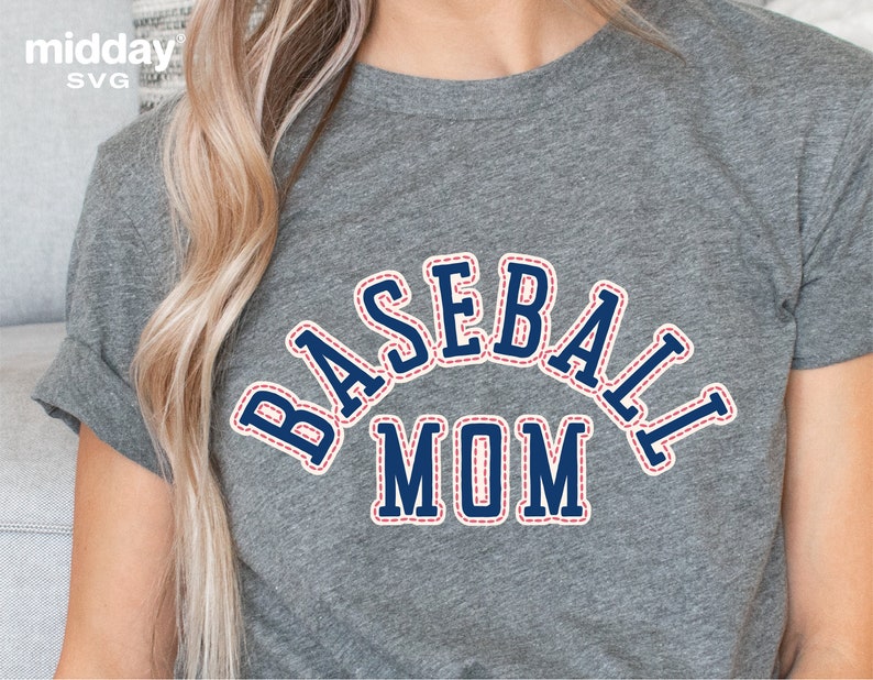 May include: Gray t-shirt with a blue and red stitched design that says "BASEBALL MOM" in a varsity style font.