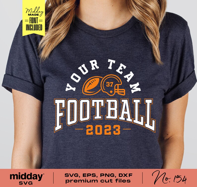 May include: A navy blue t-shirt with an orange and white design that says "Your Team Football 2023". The design includes a football and a helmet.