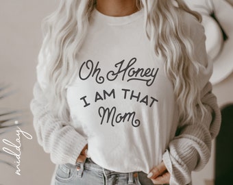 Puede incluir: Camiseta blanca con texto negro que dice "Oh Honey I Am That Mom".