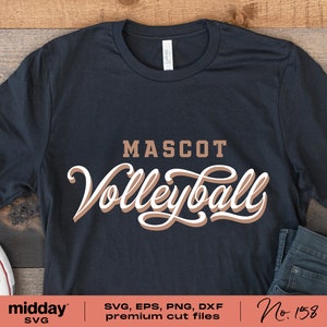 以下が含まれることがあります： 「MASCOT Volleyball」と書いてある、茶色と白のデザインの黒いTシャツです。