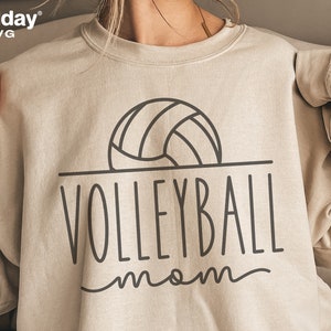 May include: A beige sweatshirt with a black outline of a volleyball and the text "VOLLEYBALL mom" in black.