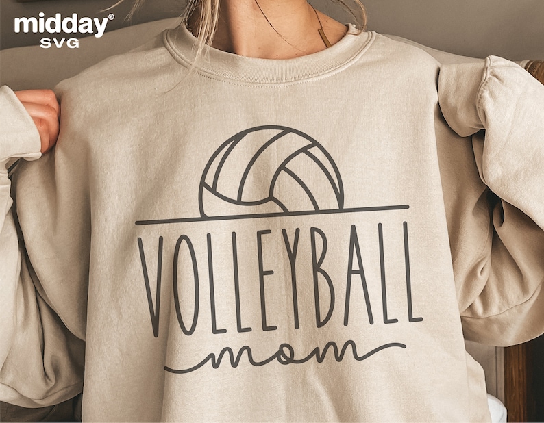 May include: A beige sweatshirt with a black outline of a volleyball and the text "VOLLEYBALL mom" in black.