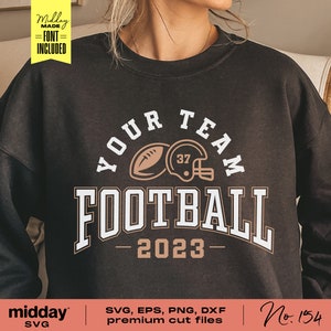 May include: A black sweatshirt with a brown and white graphic design that says "Your Team Football - 2023". The graphic includes a football and a helmet.