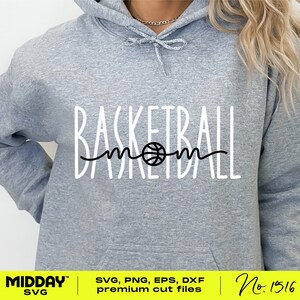 May include: A gray hoodie with the text "Basketball mom" in white with a black basketball graphic in the middle of the word "mom".