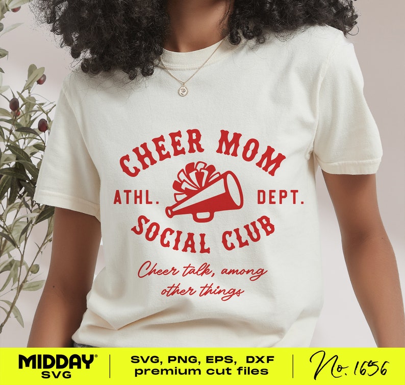 May include: White t-shirt with a red graphic that says "Cheer Mom Athl. Dept. Social Club" with a megaphone and pom poms. The text below says "Cheer talk, among other things".