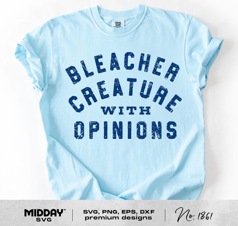 May include: Light blue t-shirt with the text "BLEACHER CREATURE WITH OPINIONS" in dark blue. The shirt has a crew neck and short sleeves. The design is a distressed, vintage style.