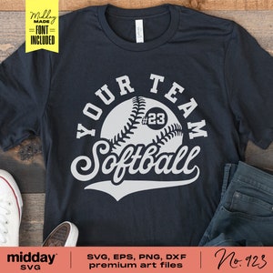 May include: A black t-shirt with a white graphic design of a softball with the text "YOUR TEAM Softball" and the number "#23" on the ball.