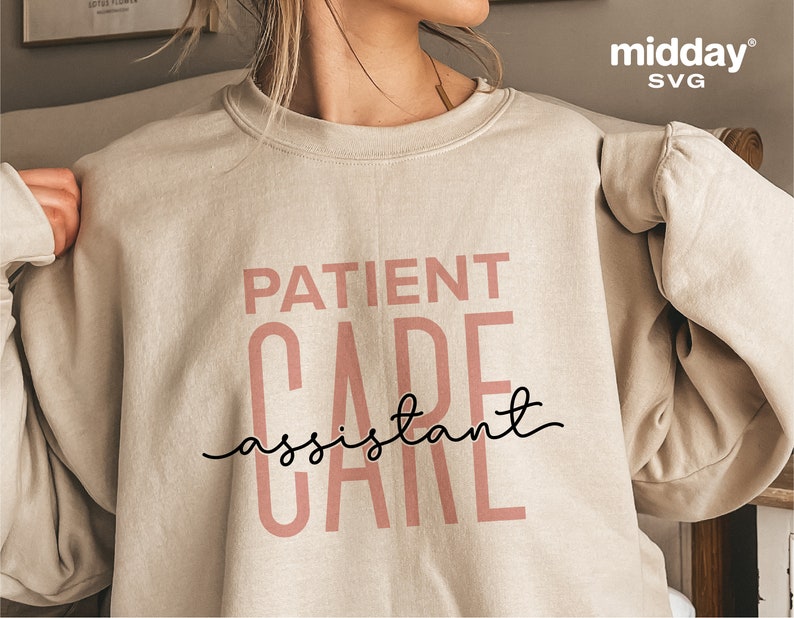 May include: A beige sweatshirt with the text "PATIENT CARE assistant CARE" printed in pink letters. The text "assistant" is written in black cursive.