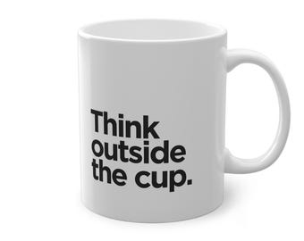 May include: White ceramic mug with the text "Think outside the cup" in black, bold font. The mug has a curved handle and a cylindrical shape, ideal for tea or coffee. The mug is a standard size.