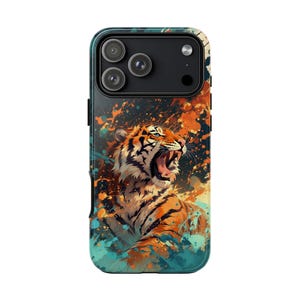 May include: A smartphone case featuring a roaring tiger illustration. The design showcases a tiger with orange and black stripes against a backdrop of orange, blue, and black paint splatters. The case has a black camera module.