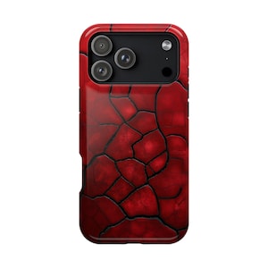 May include: A red phone case with a cracked, textured design. The case has a glossy finish and a black camera module with three lenses. The overall aesthetic is a distressed, abstract pattern.