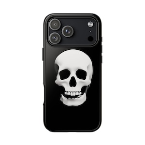 May include: A black smartphone case featuring a centered, high-contrast white human skull graphic. The skull design displays deep black eye sockets, a nasal cavity, and detailed teeth. The case includes a cutout for a triple-lens camera system.