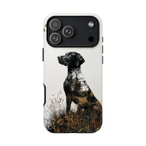 May include: A white phone case featuring a black dog illustration with a forest scene overlay. The dog is sitting in tall grass. The phone case has a black camera module and black side buttons.