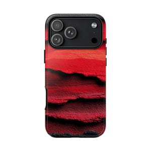 May include: A smartphone case with a vibrant abstract design in shades of red and black. The case features a textured, layered pattern that creates a sense of depth. The camera lenses are visible at the top, set against a black background.