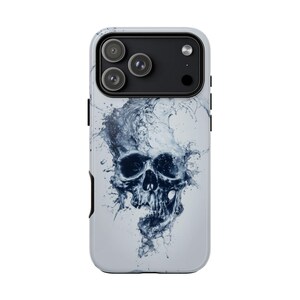 May include: A white phone case featuring a detailed, dark blue skull design. The skull appears to be made of water, with intricate details and a splash effect. The case has a black camera module.