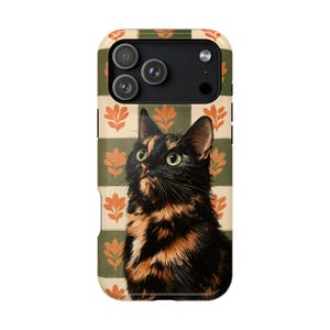 May include: A rectangular smartphone case featuring a portrait of a tortoiseshell cat with black and orange fur. The background consists of alternating horizontal stripes of olive green and cream, decorated with a repeating orange leaf pattern.