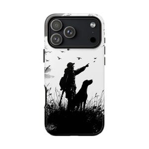 May include: A black and white phone case featuring a silhouette of a hunter with a dog pointing at flying birds. The hunter is wearing a hat and carrying a backpack. The dog is standing in tall grass. The background is a bright sky.