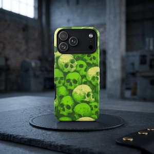 May include: A green and white skull-patterned phone case. The case features a repeating design of skulls in varying shades of green and white. The phone case is shown on a black surface.