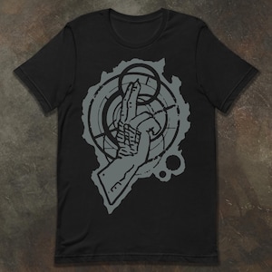 Może przedstawiać: Czarny t-shirt z szarą grafiką dłoni z dwoma uniesionymi palcami, na tle geometrycznych kształtów i okręgów. Projekt ma postarzaną, vintage estetykę. Koszulka wykonana jest z miękkiego materiału.