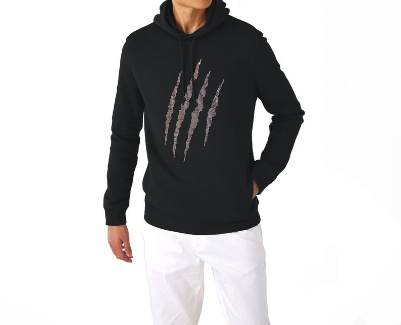May include: Black hooded sweatshirt with a claw mark design on the front. The claw marks are made of a lighter color, possibly silver or gray, and are vertically oriented. The sweatshirt has a front pocket and long sleeves.