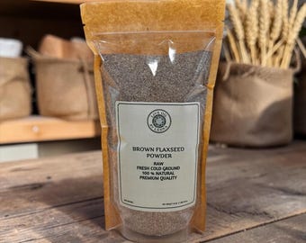 Może przedstawiać: Stojąca torebka zawierająca brązowy proszek z siemienia lnianego. Etykieta zawiera napis: Live Oil By Lesna, Brown Flaxseed Powder, Raw, Fresh Cold Ground, 100% Natural, Premium Quality. Waga netto 453 gramy jest podana w prawym dolnym rogu.