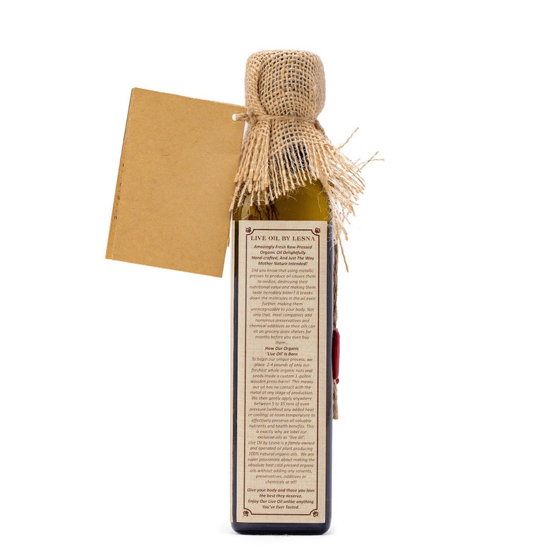 May include: A glass bottle of Live Oil by Lesna, a raw pressed organic oil. The bottle is wrapped in burlap and has a brown paper tag attached. The label reads "Amazingly Fresh Raw Pressed Organic Oil Delightfully Hand-Crafted. And Just The Way Nature Intended."