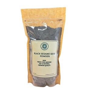 Może przedstawiać: Przezroczysta torebka wypełniona czarnym proszkiem z nasion sezamu. Torebka ma brązowe papierowe tło i etykietę z napisem "Black Sesame Seed Powder" i "Raw Fresh Cold Ground 100% Natural Premium Quality".