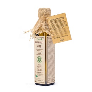 May include: A glass bottle of organic walnut oil with a brown label. The label says "Organic Walnut Oil" and "Live Oil by Lesna". The bottle is 8.45 fl oz (250 ml).
