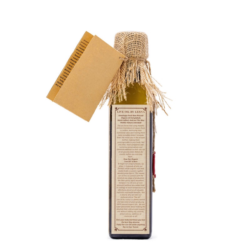 May include: A glass bottle of Live Oil by Lessna, a cold-pressed, unfiltered, and unrefined olive oil. The bottle is wrapped in burlap and has a red wax seal. The label describes the oil as being made with the highest quality olives and is free of chemical additives. The label also states that the oil is 100% organic and cold-pressed.