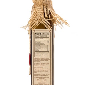 May include: A glass bottle of organic almond oil with a burlap covering. The bottle label includes the product name, ingredients, nutrition facts, and the company's contact information. The label also states that the oil is gluten-free, vegan, non-GMO, and certified organic.