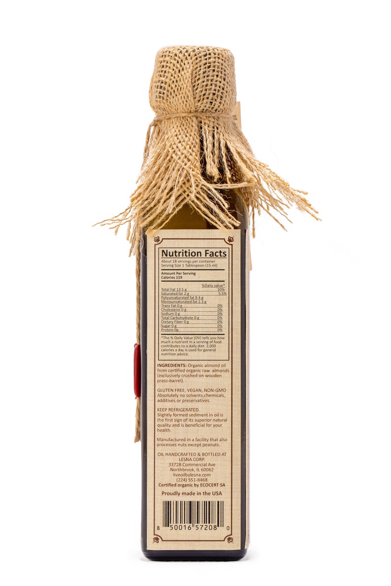 May include: A glass bottle of organic almond oil with a burlap covering. The bottle label includes the product name, ingredients, nutrition facts, and the company's contact information. The label also states that the oil is gluten-free, vegan, non-GMO, and certified organic.