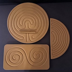 May include: Three wooden maze puzzles in different shapes and sizes. The first is a round maze with a central spiral, the second is a half-circle maze with concentric circles, and the third is a rectangular maze with two connected spirals.