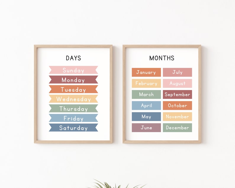 May include: Two framed prints with colorful banners listing the days of the week and the months of the year. The days of the week are listed in a vertical column on the left print, and the months of the year are listed in two vertical columns on the right print.