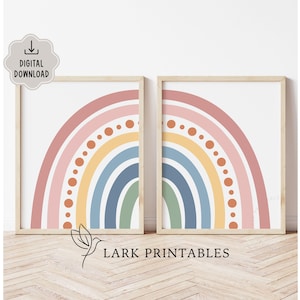 Op de afbeelding: Twee ingelijste prints met een regenboogontwerp in pasteltinten van roze, oranje, geel, blauw en groen. De prints zijn gelabeld met "Digitale download" en "Lark Printables".