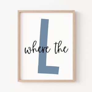 May include: A framed print with a light blue letter L and the text "where the" in black cursive font.