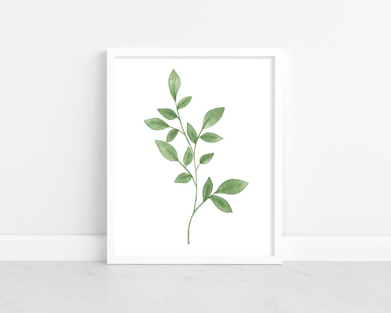 May include: A white framed print featuring a watercolor illustration of a single green leafy branch with delicate leaves.